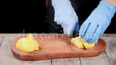厨师在手套上切柠檬在木切割板上。 餐厅的食物咕咕叫。 慢动作。 <strong>高清高清</strong>